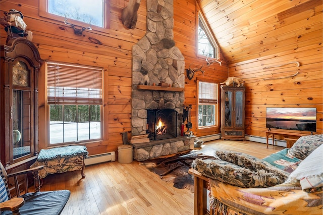 living area with a baseboard heating unit, high vaulted ceiling, and hardwood / wood-style floors