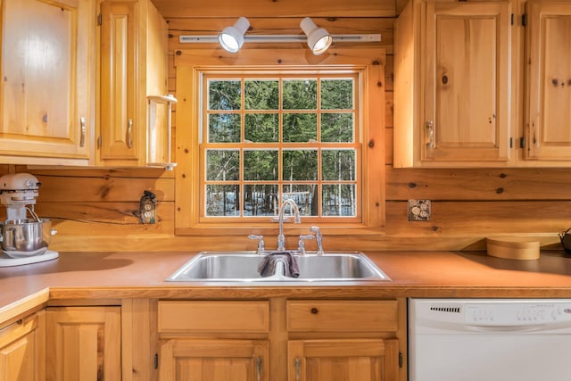 kitchen with light brown cabinets, dishwasher, light countertops, and a sink