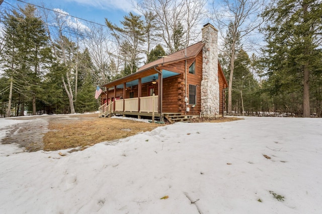 view of property exterior featuring a porch, log siding, and a chimney