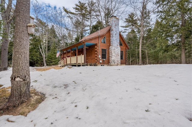 view of front of home featuring log siding and a chimney