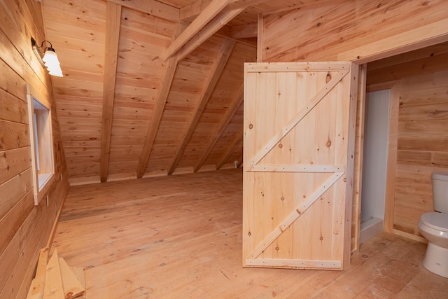 additional living space with lofted ceiling with beams, wood walls, wood ceiling, and light wood finished floors