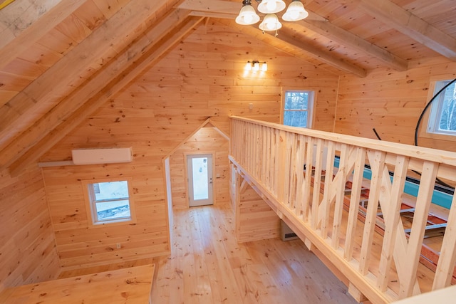 additional living space with light wood-type flooring, vaulted ceiling with beams, wood ceiling, and wooden walls