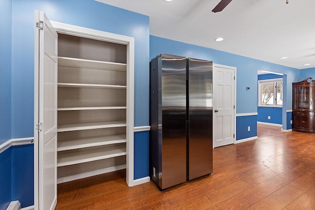 kitchen featuring baseboards, a ceiling fan, hardwood / wood-style floors, freestanding refrigerator, and recessed lighting