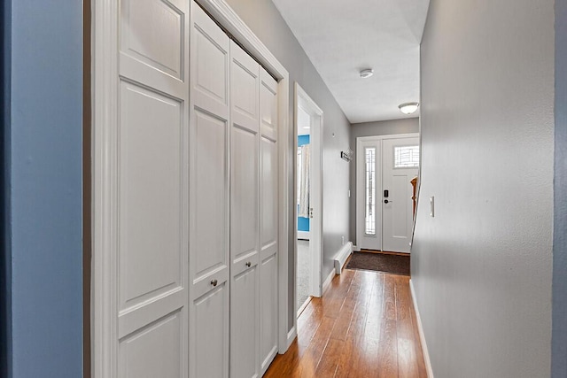 doorway featuring wood-type flooring and baseboards