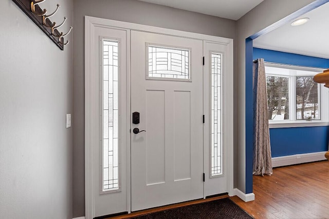 foyer entrance featuring baseboards and wood finished floors