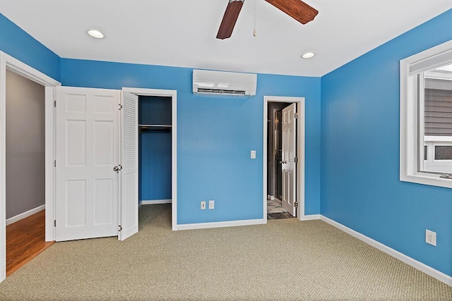 unfurnished bedroom with carpet floors, recessed lighting, a wall mounted air conditioner, and baseboards