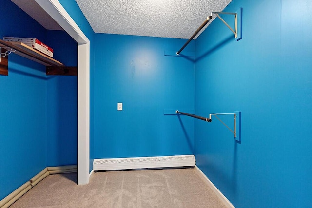 walk in closet with a baseboard heating unit and carpet flooring