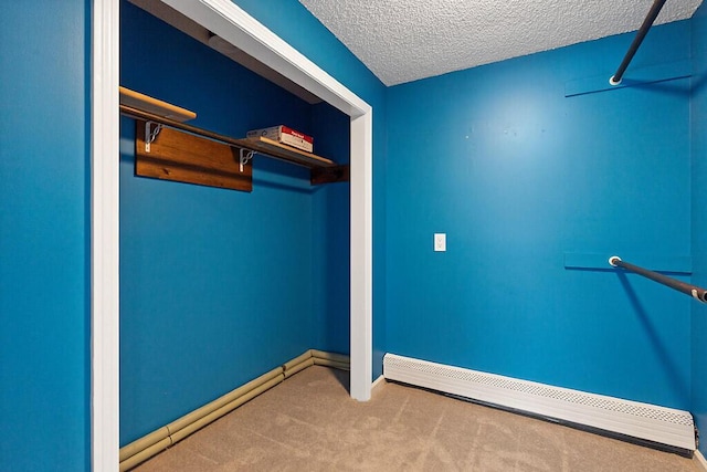 spacious closet featuring a baseboard radiator and carpet flooring