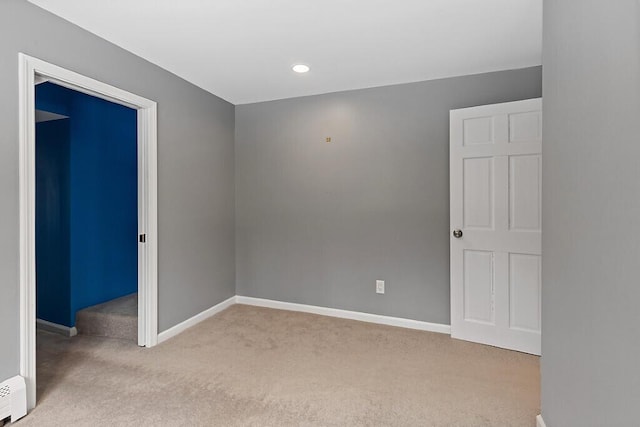 unfurnished room featuring a baseboard heating unit, baseboards, carpet flooring, and recessed lighting