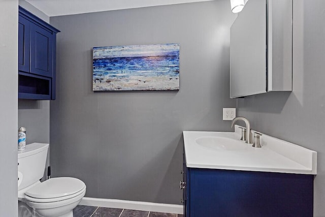 bathroom featuring toilet, baseboards, and vanity