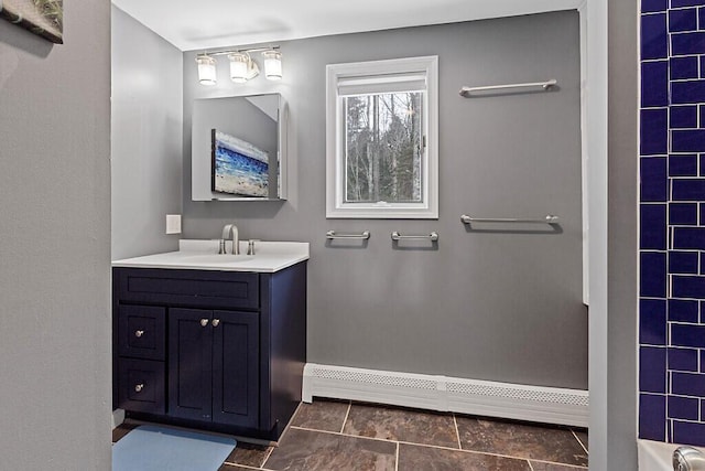 bathroom featuring a shower, baseboards, vanity, and baseboard heating