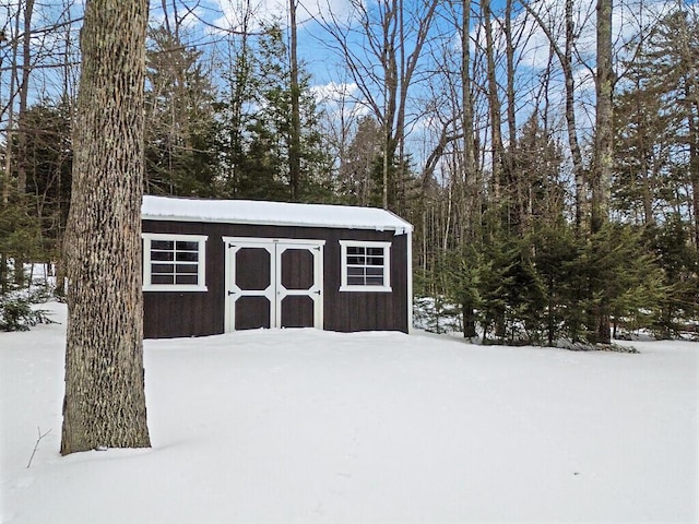 snow covered structure with a storage unit and an outdoor structure