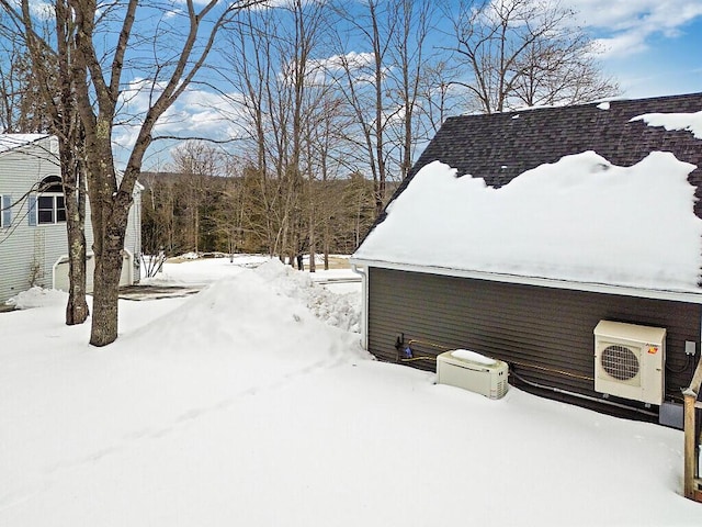 yard layered in snow featuring ac unit