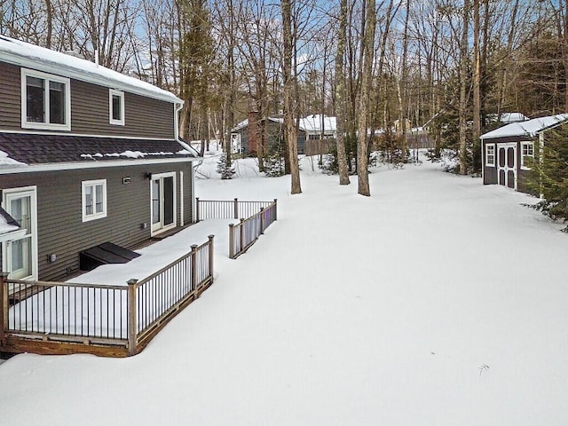 yard covered in snow with an outbuilding