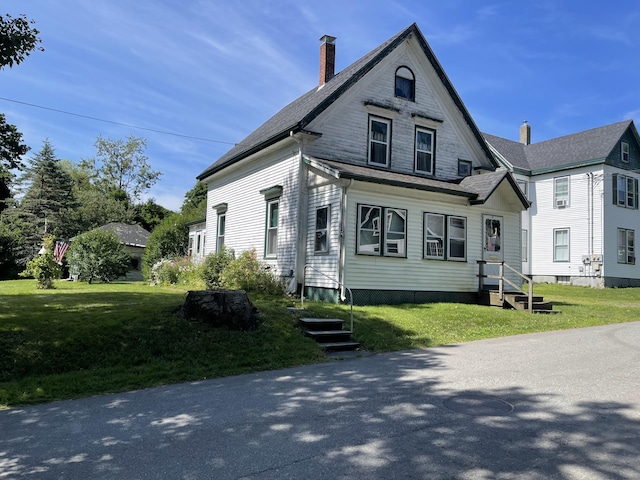 view of front of home featuring entry steps and a front yard