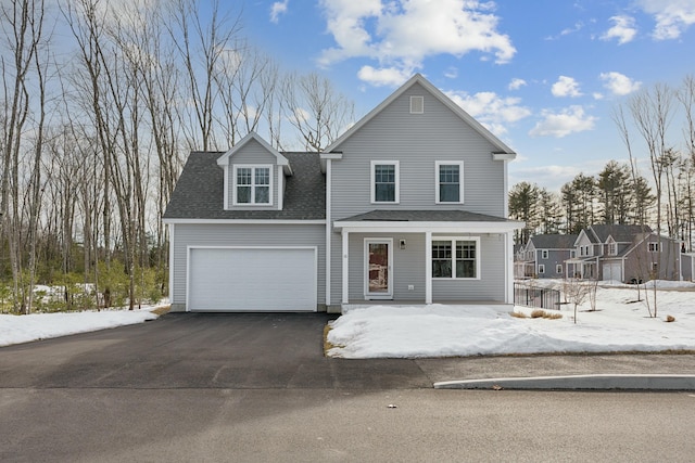 traditional home with driveway, a garage, and roof with shingles