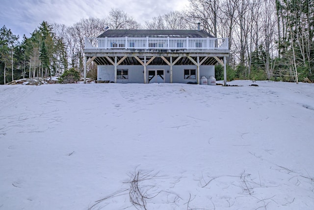 snow covered property with a deck