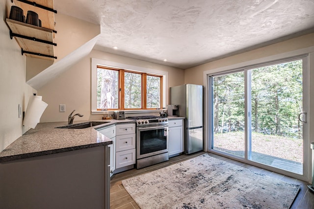 543 Middle Rd, Dresden, ME 04342 - kitchen with appliances with stainless steel finishes, a sink, dark stone counters, recessed lighting, and wood tiled floors