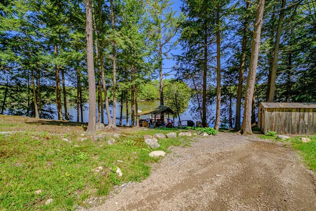 543 Middle Rd, Dresden, ME 04342 - view of yard with a water view, an outbuilding, and dirt driveway
