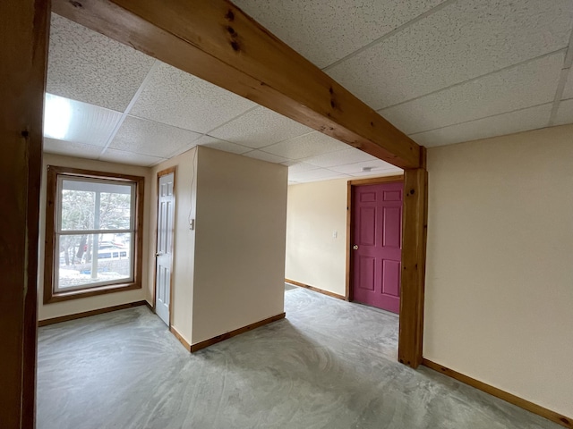 empty room with a drop ceiling and baseboards