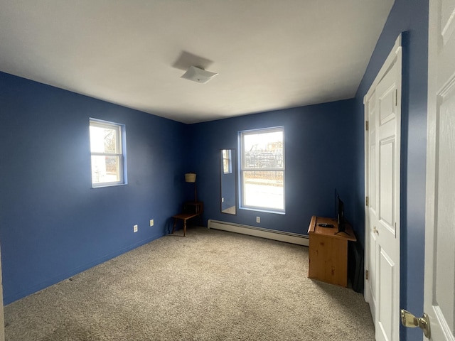 unfurnished bedroom featuring a baseboard heating unit and carpet floors