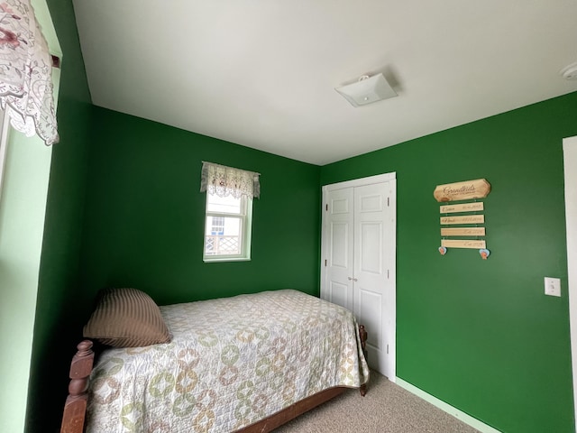 bedroom with a closet, carpet flooring, and baseboards