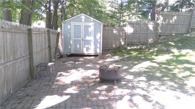 view of patio featuring an outbuilding, a fenced backyard, and a storage unit