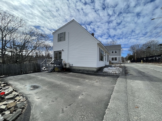 view of property exterior featuring a chimney and fence