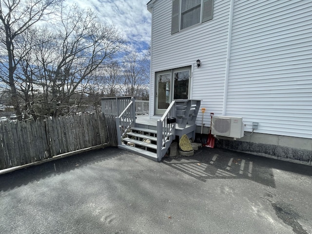 view of patio with ac unit, a wooden deck, and fence