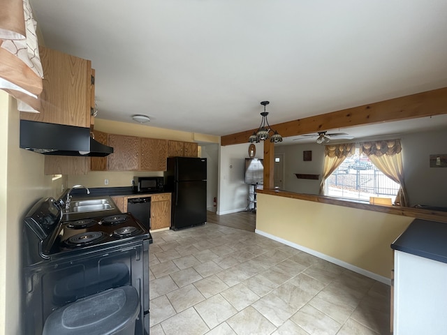 kitchen featuring dark countertops, a sink, black appliances, under cabinet range hood, and baseboards