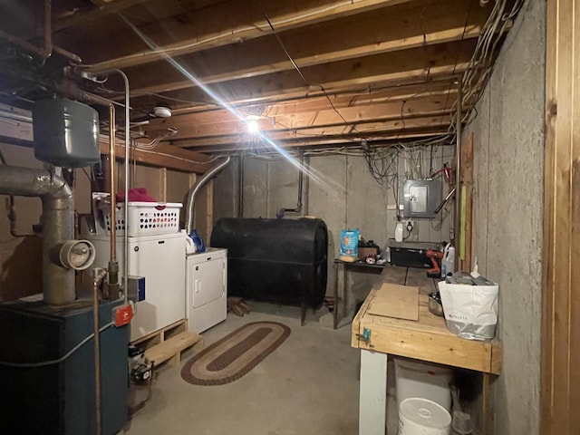 unfinished below grade area with heating fuel, electric panel, and independent washer and dryer