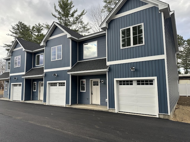 modern farmhouse with board and batten siding, a shingled roof, and an attached garage