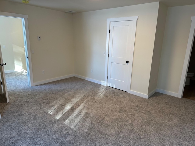 spare room featuring carpet floors and baseboards