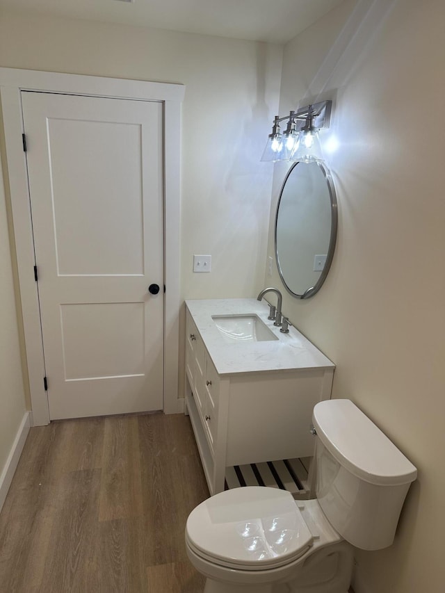 bathroom with vanity, wood finished floors, and toilet