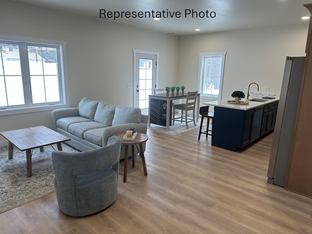 living room with a wealth of natural light, light wood-style flooring, and recessed lighting