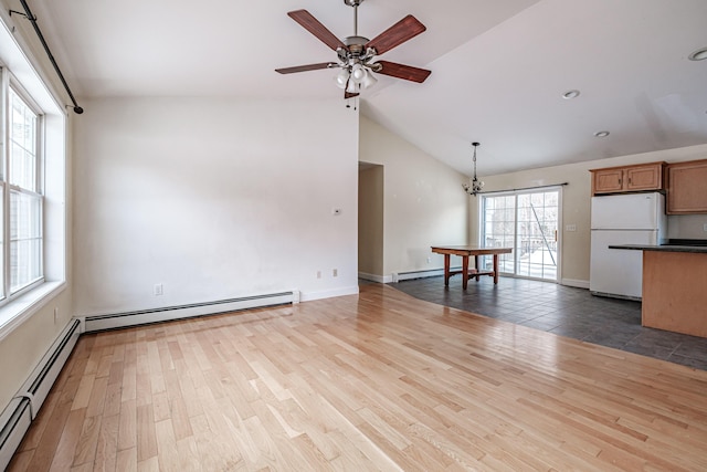 unfurnished living room featuring lofted ceiling, ceiling fan with notable chandelier, a baseboard radiator, and wood finished floors