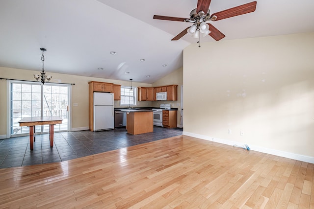 kitchen featuring white appliances, open floor plan, dark wood finished floors, and a center island