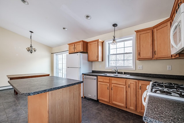 kitchen with vaulted ceiling, white appliances, dark countertops, and a sink