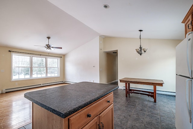 kitchen with a baseboard heating unit, dark countertops, lofted ceiling, and freestanding refrigerator