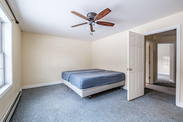 unfurnished bedroom featuring a baseboard heating unit, ceiling fan, carpet floors, and baseboards