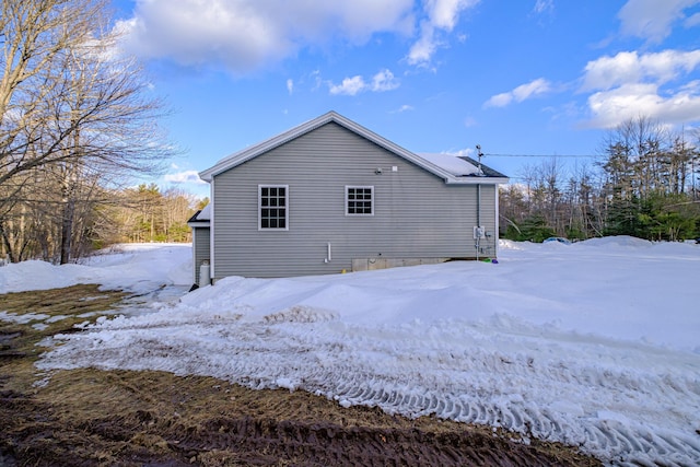 view of snow covered rear of property