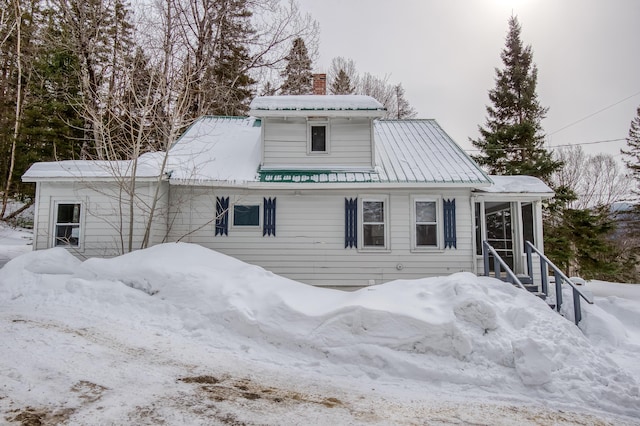 view of front of home featuring metal roof and a chimney