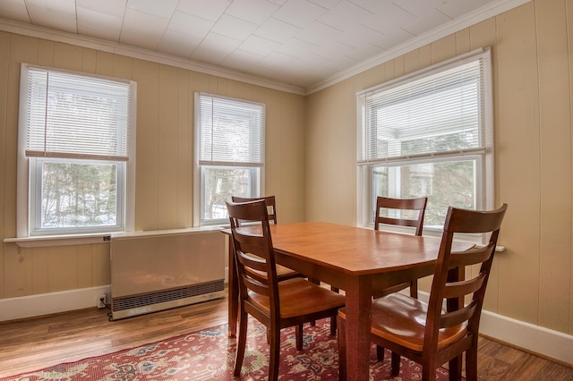 dining area featuring ornamental molding, baseboards, and wood finished floors