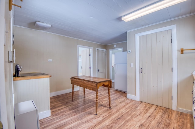 entryway featuring ornamental molding, light wood-style flooring, and baseboards