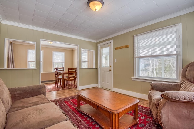 living area featuring plenty of natural light, ornamental molding, and wood finished floors