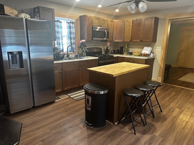 kitchen with a sink, stainless steel appliances, wood counters, and dark wood finished floors