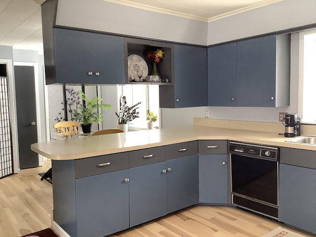 kitchen featuring black dishwasher, crown molding, light countertops, light wood-style flooring, and a peninsula