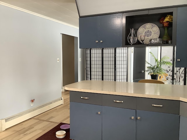 kitchen featuring light wood finished floors, a baseboard radiator, ornamental molding, gray cabinets, and light countertops