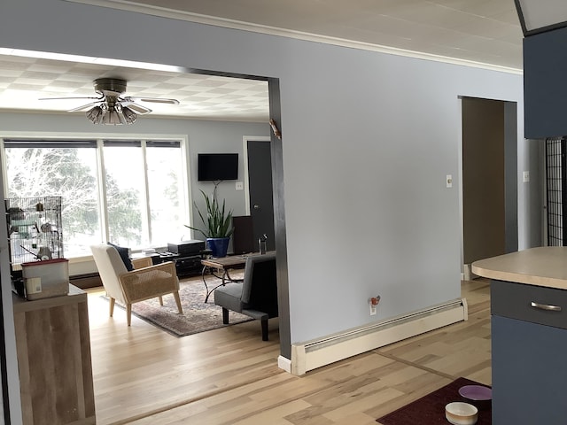 dining room featuring a baseboard heating unit, light wood-style floors, a ceiling fan, and crown molding