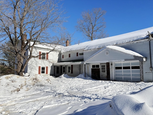 view of front of property featuring a chimney and an attached garage